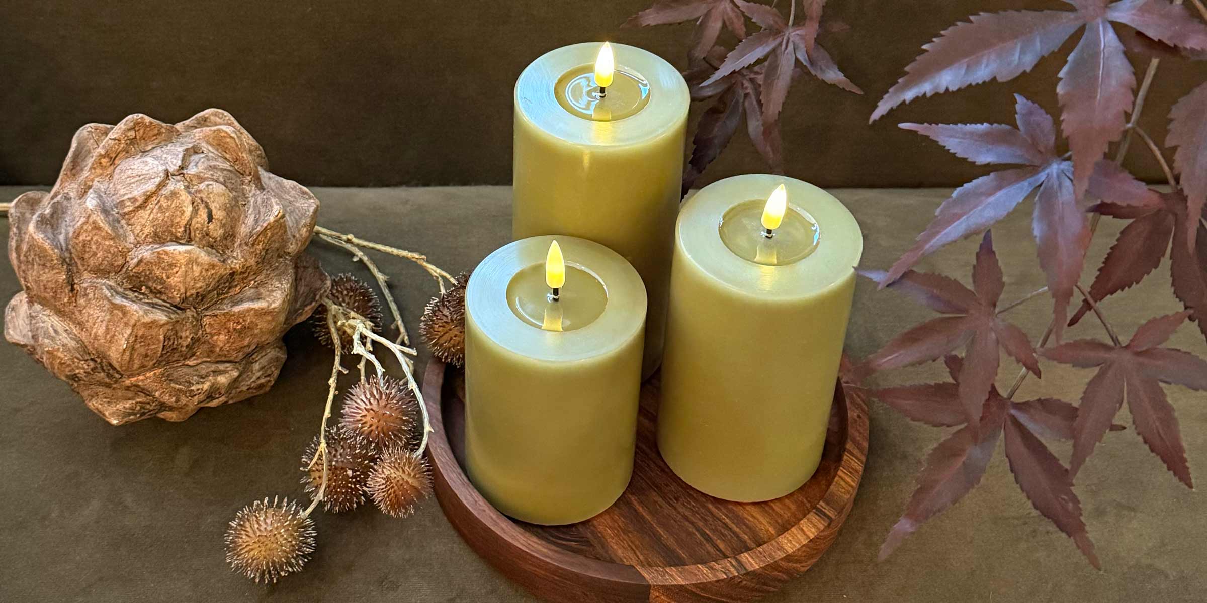 Olive Green LED Candles displayed with wooden artichoke and wooden candle plate
