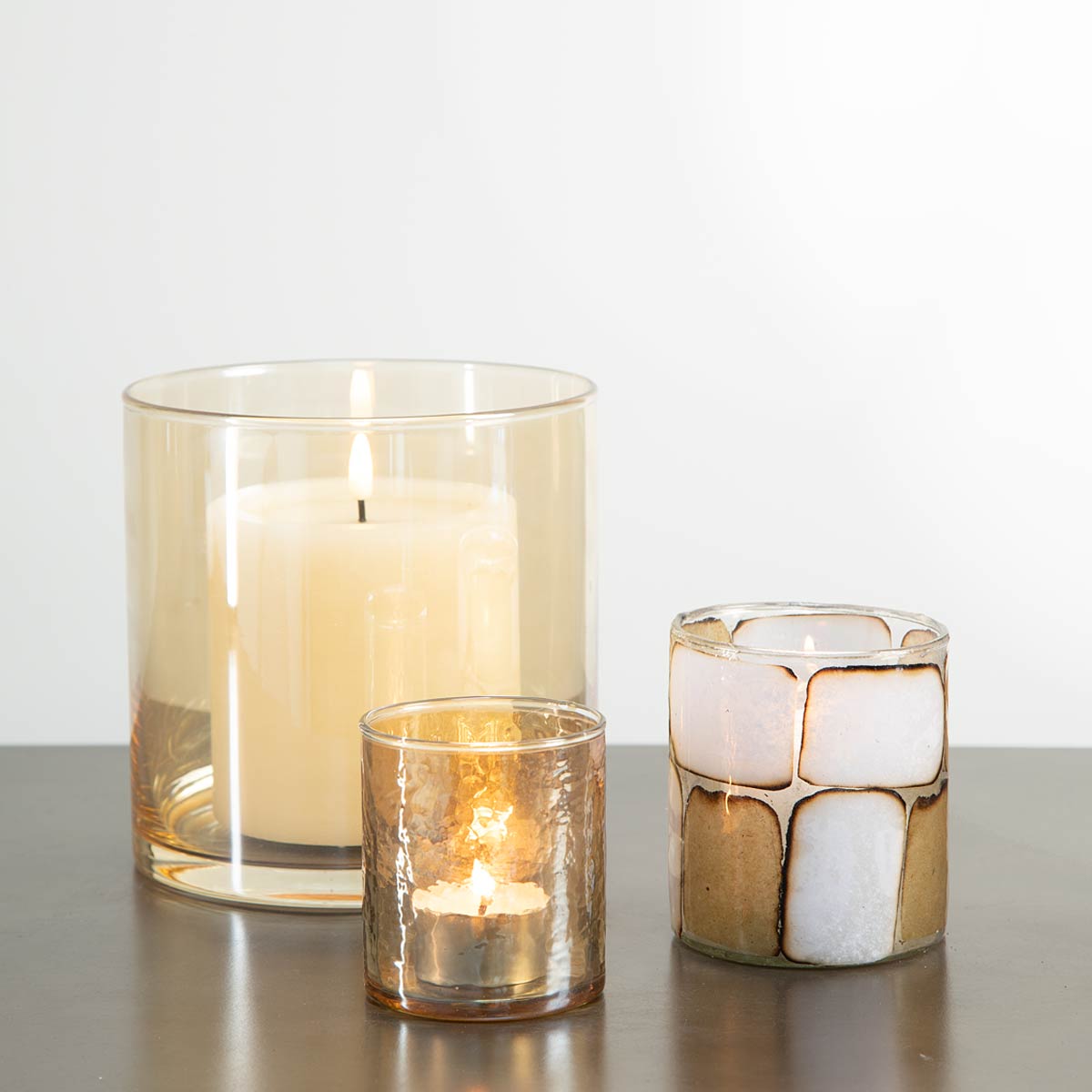 Amber Glass Candle Holder with pillar candle displayed with other votives