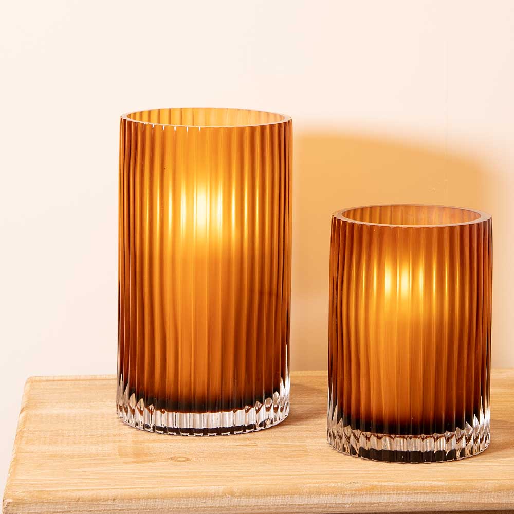 Two Amber Smoke Fluted Vase shown with LED Candles giving off a warm glow on console