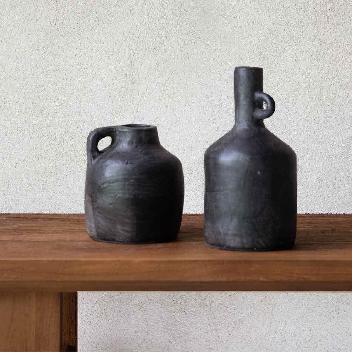 Black terracotta Baku Short Vase styled with the Baku Tall Vase on a wooden shelf