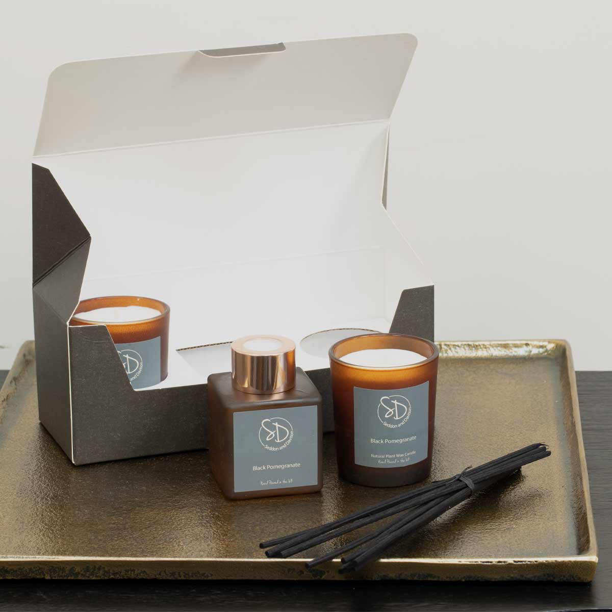 Black Pomegranate Home Fragrance Gift Set – reed diffuser and two votive candles in amber glass - Partly shown in box
