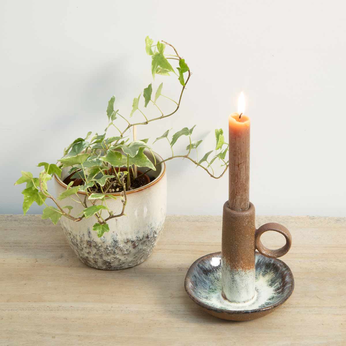 Brown Ombre Candle Holder with reactive glaze styled with lit candle on console table with plant