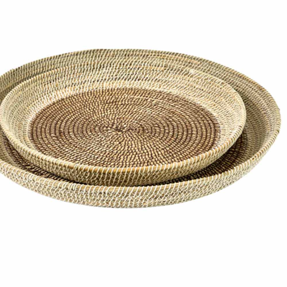 Two nested round woven trays made from natural seagrass, shown on a plain white background.