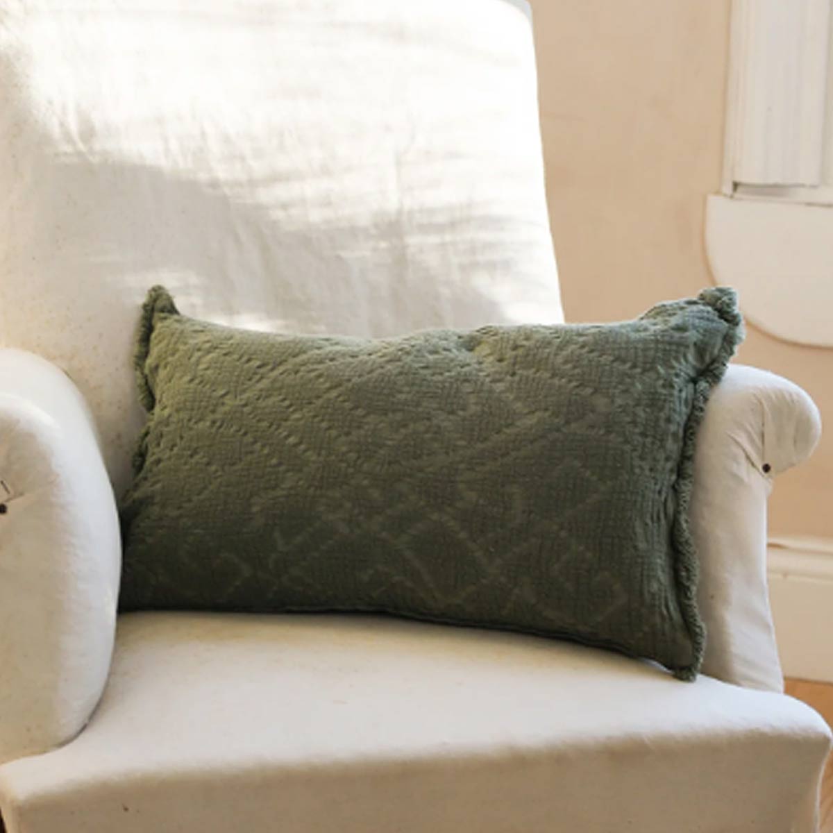 Chantilly Cushion in Olive – 100% cotton with lace-style waffle texture and frayed edges, styled in a rustic country interior