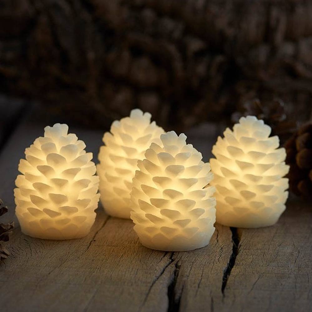 Four pine cone-shaped LED candles on a wooden surface with a blurred natural background