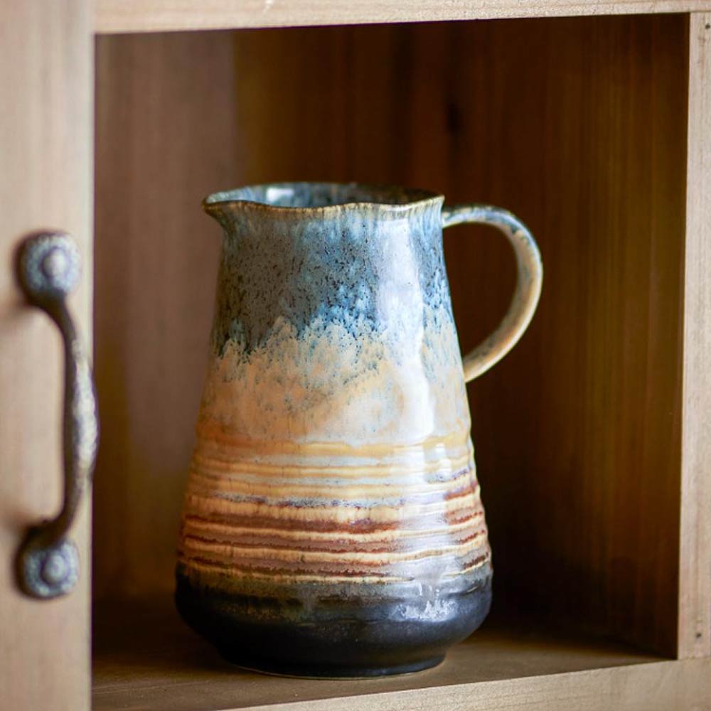 Ceramic Deana Jug with a brown and blue reactive glazed surface on a wooden shelf