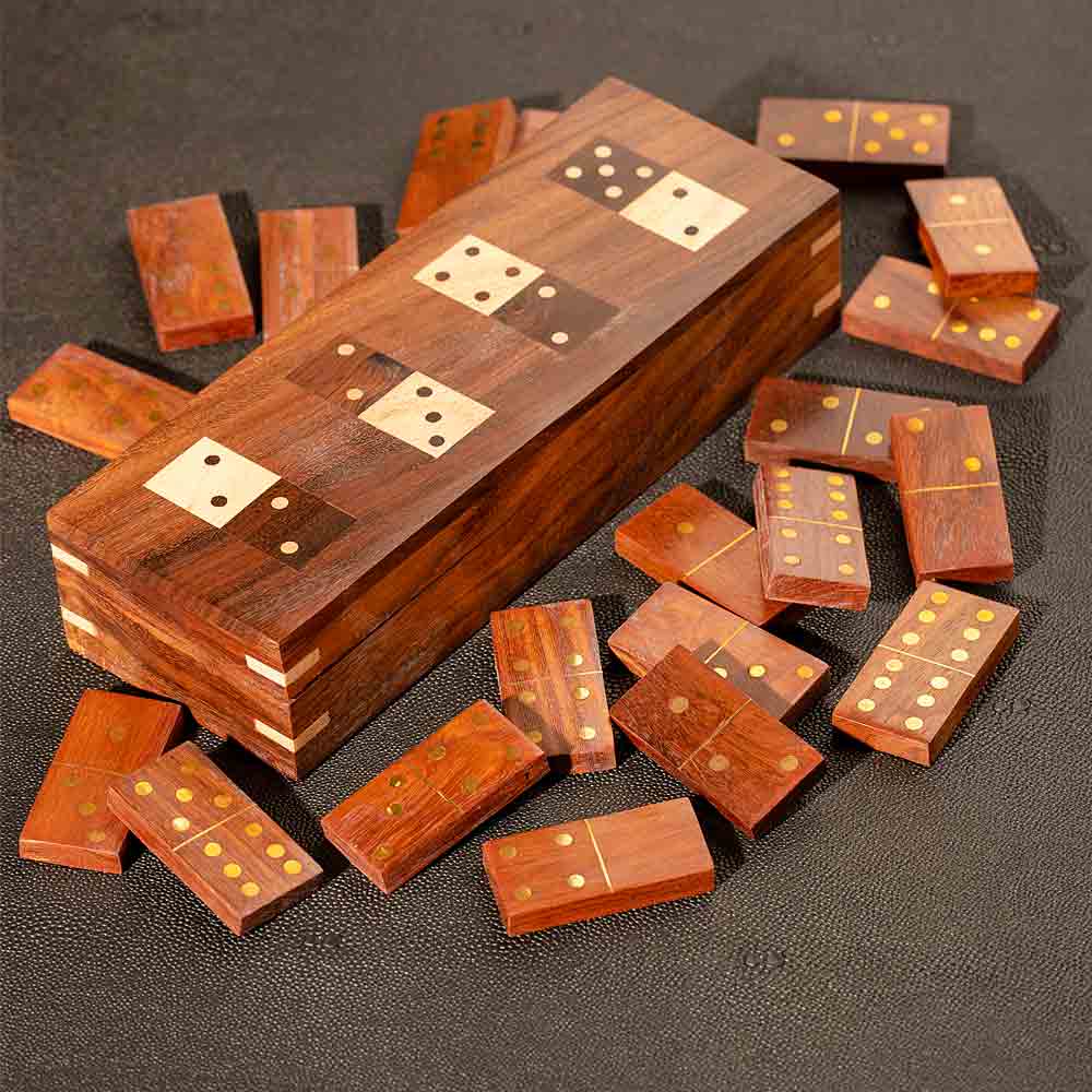 Wooden domino set with pieces scattered on a dark surface