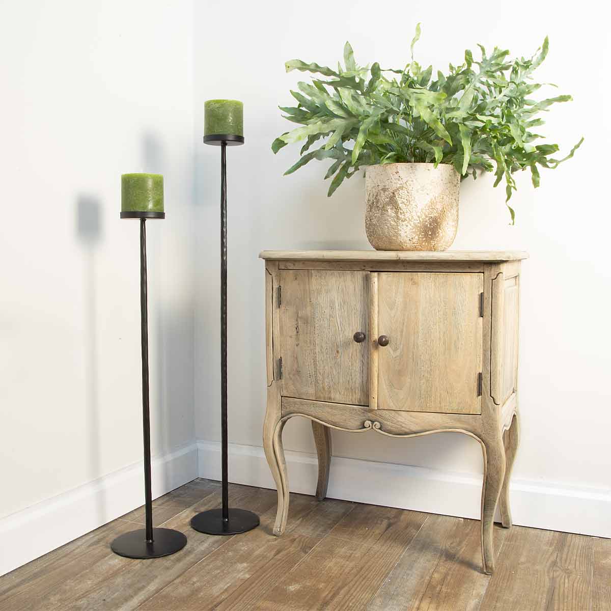 Esine Matt Black Candle Holders displayed with green pillar candles and rustic cupboard