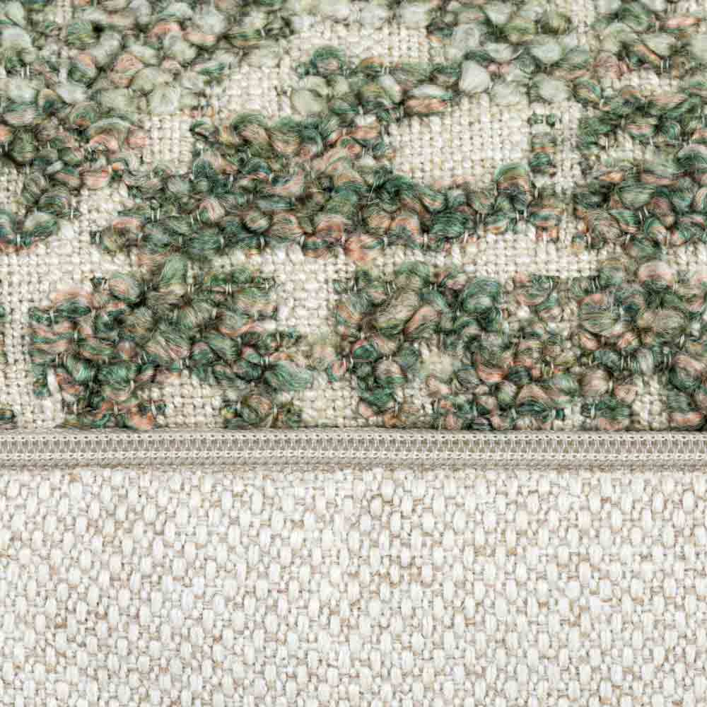 Close-up of the Esme Oblong Cushion’s zip and boucle fabric, showcasing the detailed woven texture in green and rose tones.