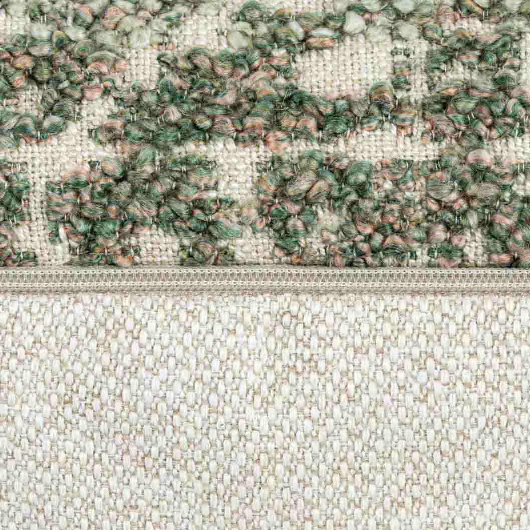 Close-up of the Esme Oblong Cushion’s zip and boucle fabric, showcasing the detailed woven texture in green and rose tones.