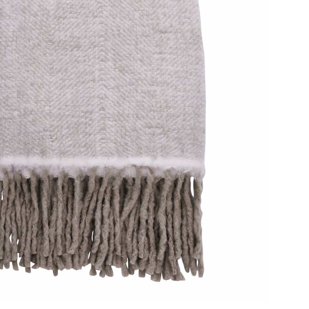 Close up of Essia cool ivory wool herringbone throw with grey fringe detailing - 170×130cm - on white background white background