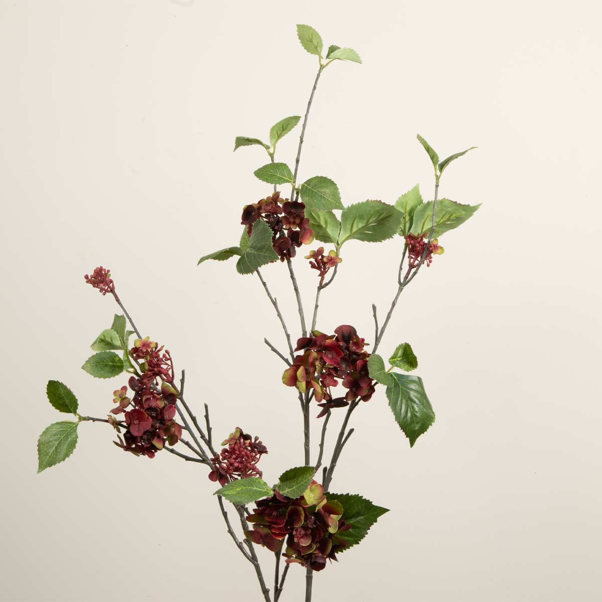 Artificial Hydrangea spray with red and green flowers and leaves on a white background.