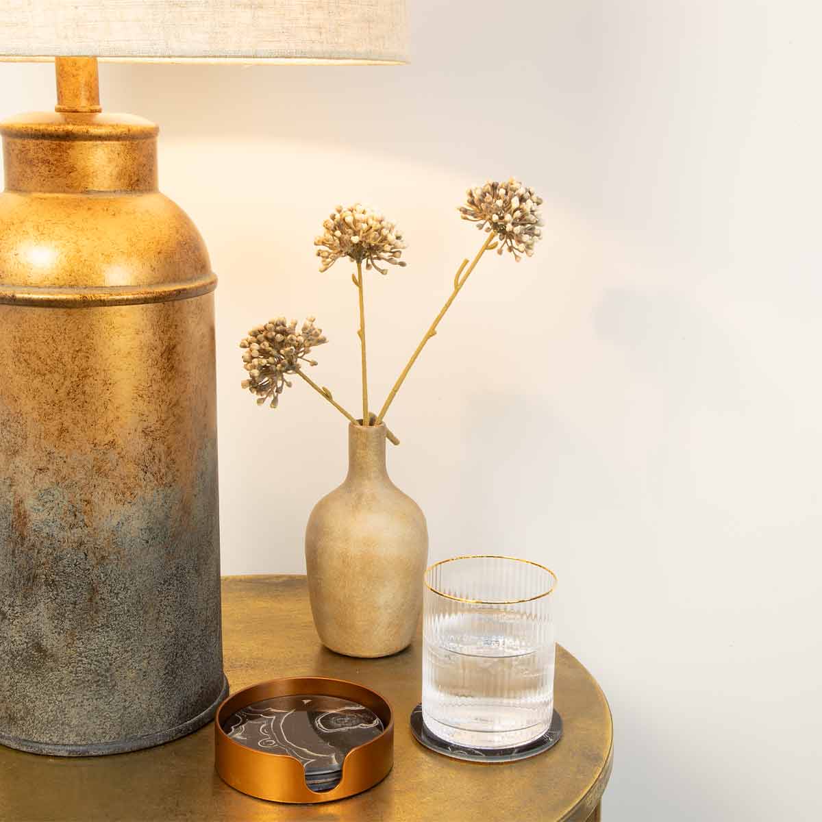 Glass Marble-Effect Black Coasters - Set of 4 displayed on gold table table with lamp and vase