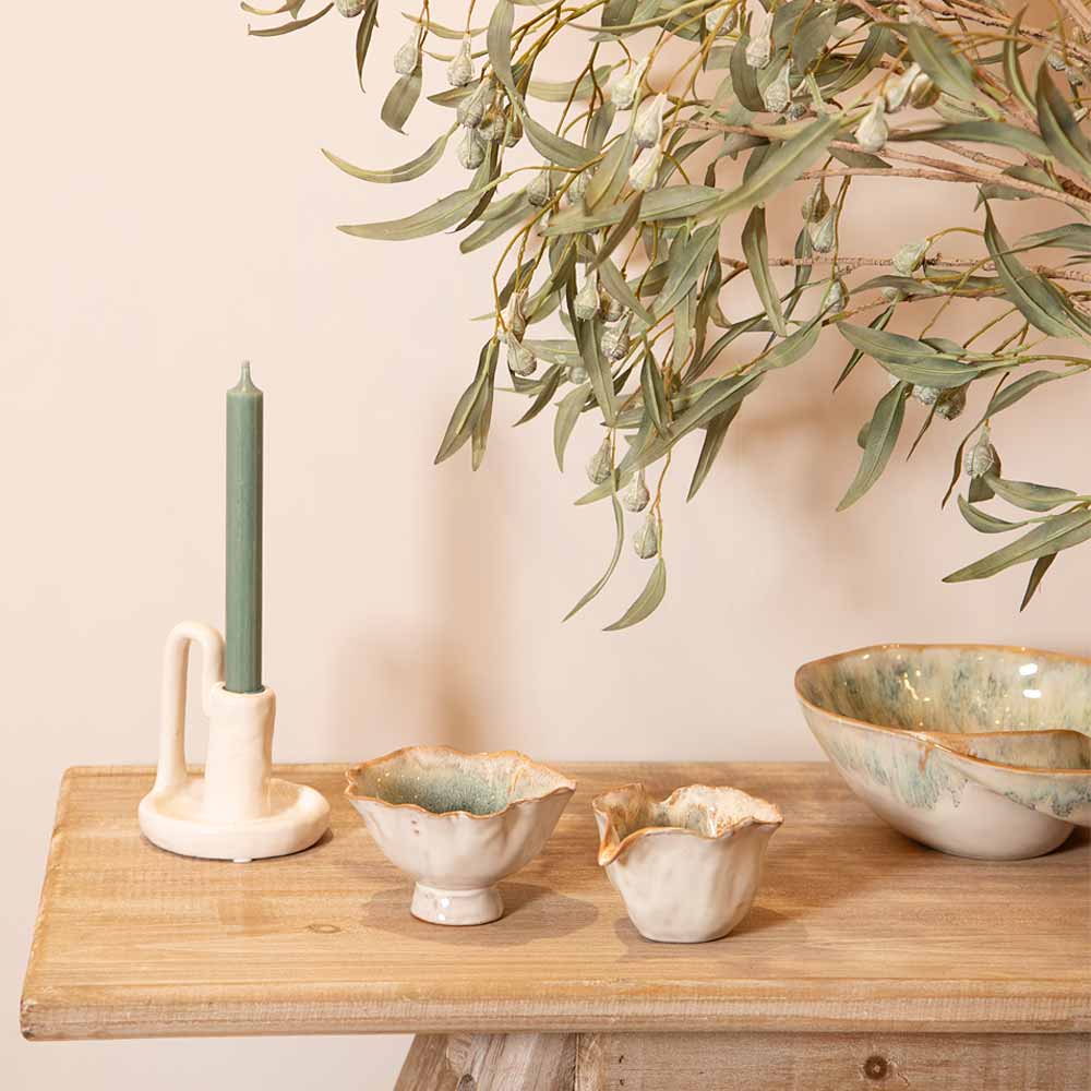 Decorative setting with Green Ombre Milk and Sugar Bowls and a candle on a wooden surface, featuring a plant in the background.
