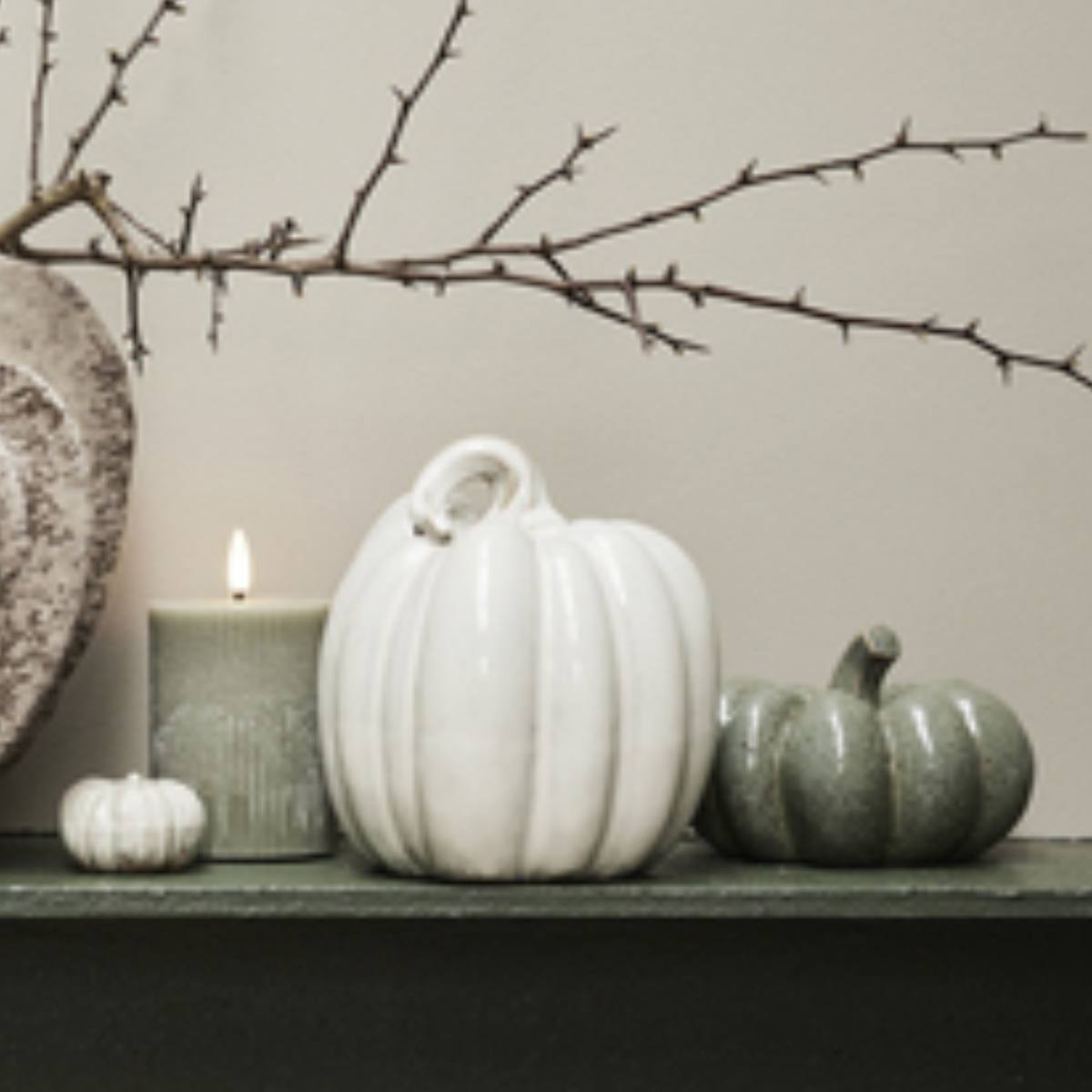 Decorative arrangement with Large white  Hallia Ceramic Pumpkin and a candle on a shelf