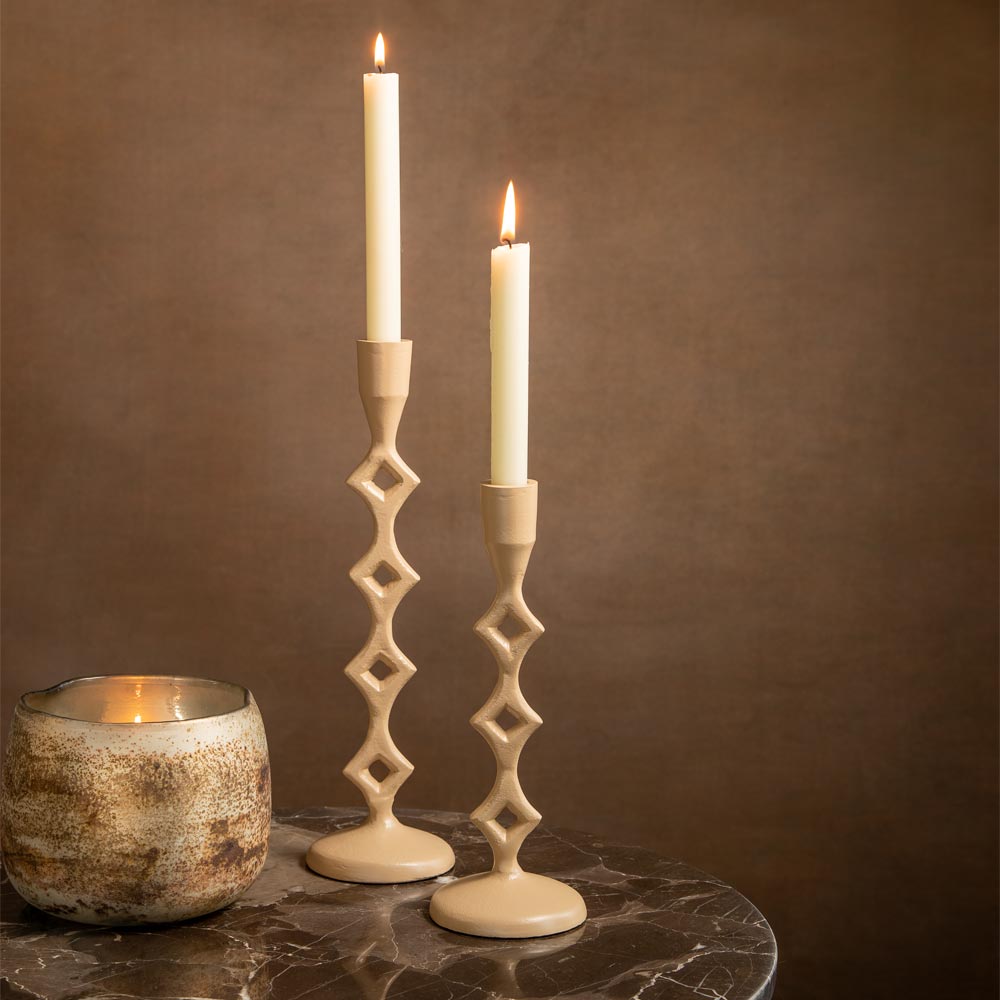 Jerula Candlesticks in a Sand Colour on a brown marble table