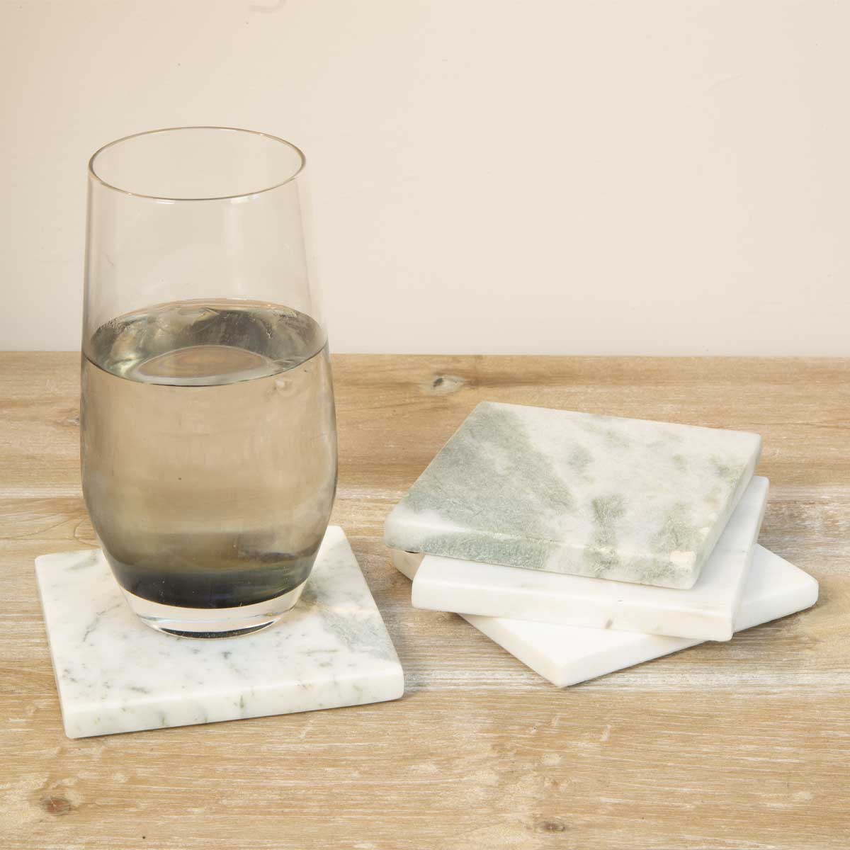 A set of four handcrafted Lady Onyx marble coasters with natural green and pink veining, ethically sourced from Agra, India.