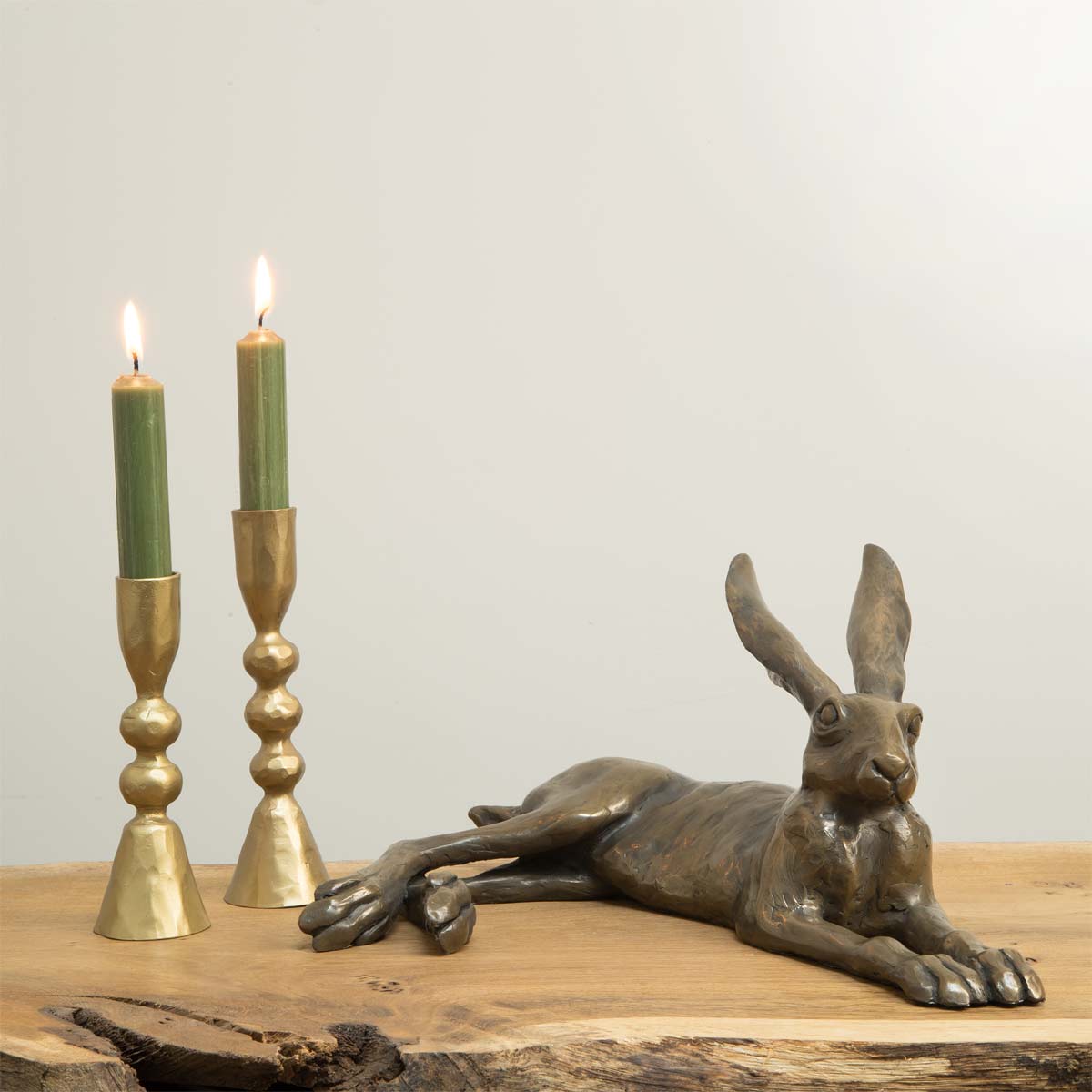 Laid Back Hare Bronze Resin Sculpture - Displayed with Gold candlesticks