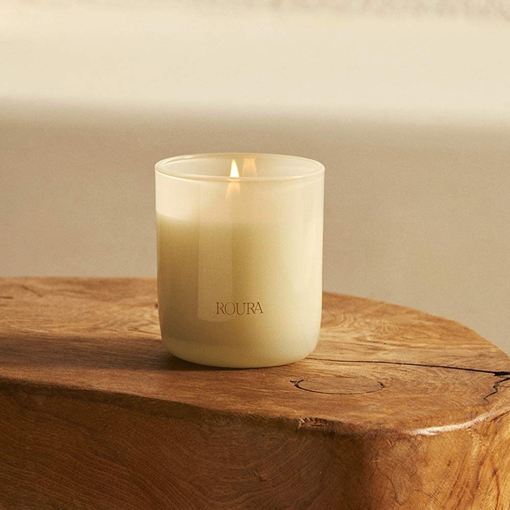 Majestic Lotus Glass Jar Candle by Roura on a wooden surface