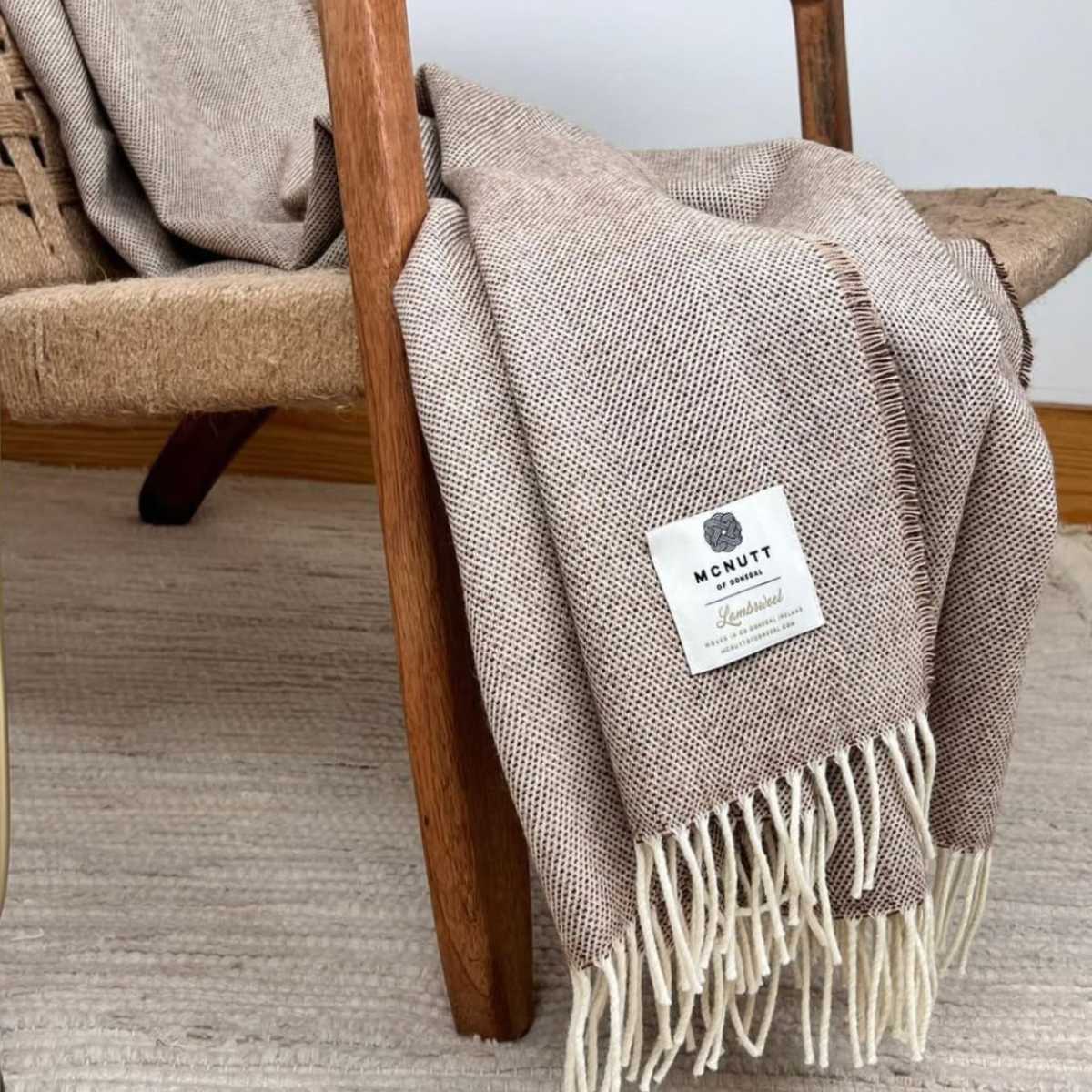 McNutt Throw in Spotted Butterscotch draped over rustic chair.