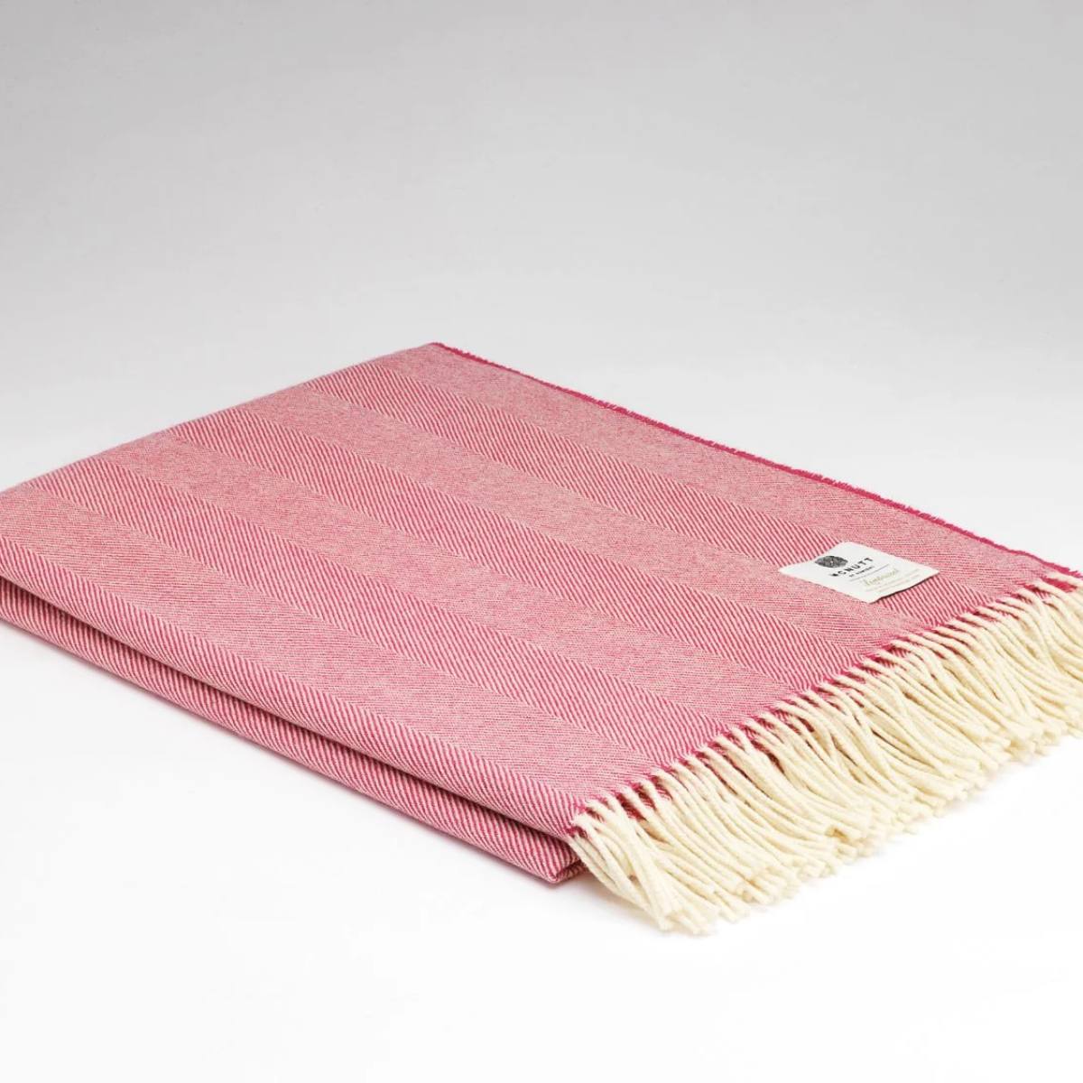 Raspberry Merino Wool Herringbone Throw – folded McNutt of Donegal blanket showing herringbone weave on light grey background