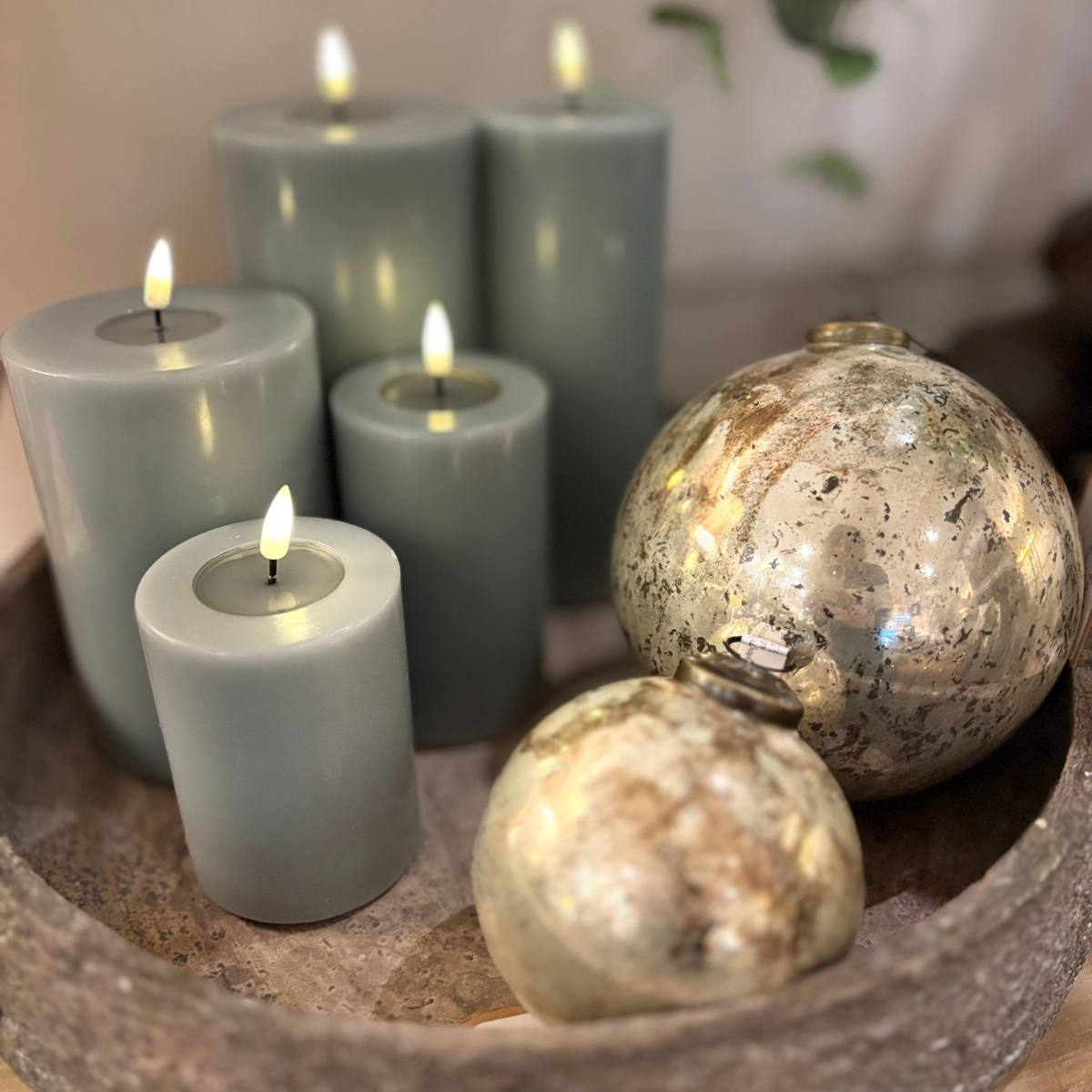 Myleigh Cream Round Glass Baubles in the large and small size styled with candles on a cement bowl