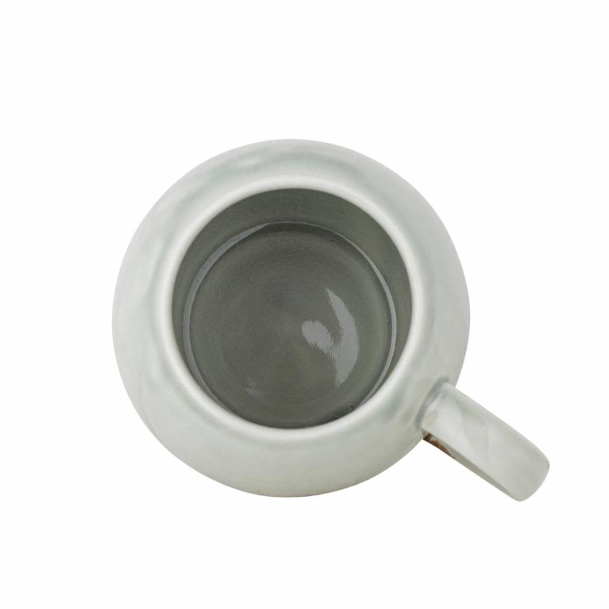 Paula stoneware mug with light blue and brown reactive glaze -viewed from above on white background