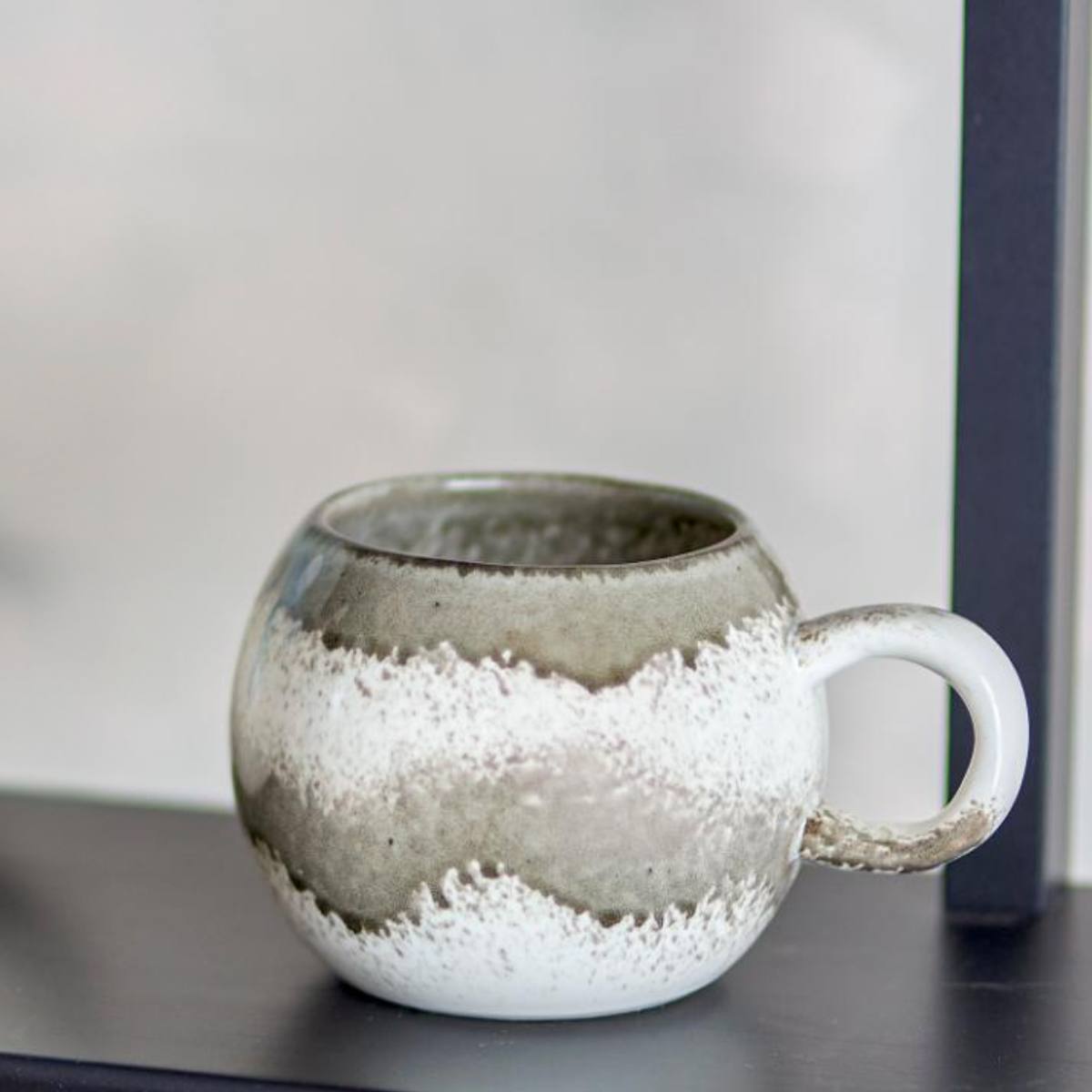 Paula stoneware mug in grey and white on display shelf