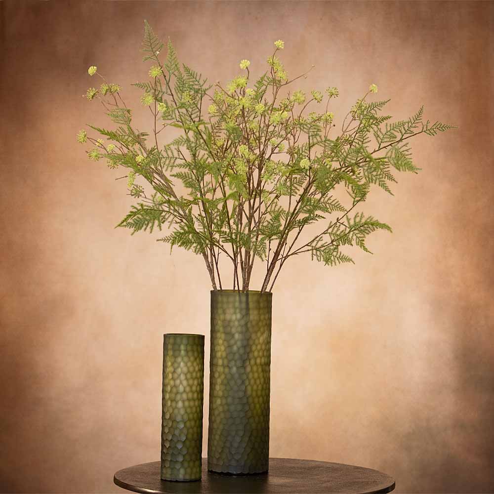 Two green vases with decorative patterns, one taller than the other, against a brown background.