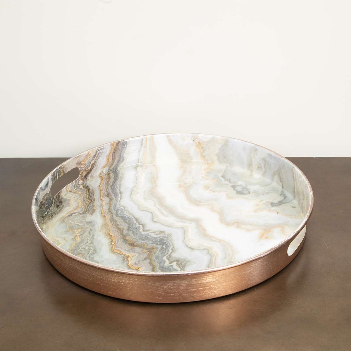 Angled view of round Rose Gold Marble Effect Tray with swirling marble pattern
