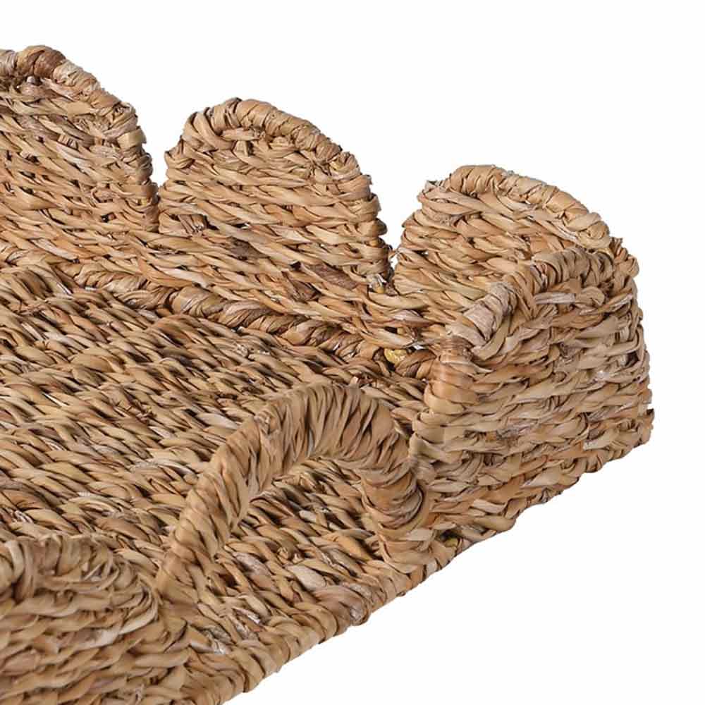 Woven seagrass tray with a Scalloped shape on a white background
