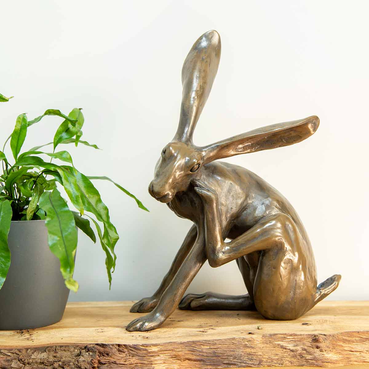 Scratching Hare bronze resin sculpture handmade in the UK – Joanna Martins design on rustic wooden shelf