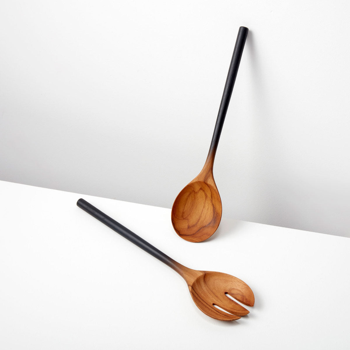 Teak Black Ombre Serving Spoon & Fork Set with hand-dipped ombre handles, handcrafted in Thailand, displayed on a white surface.