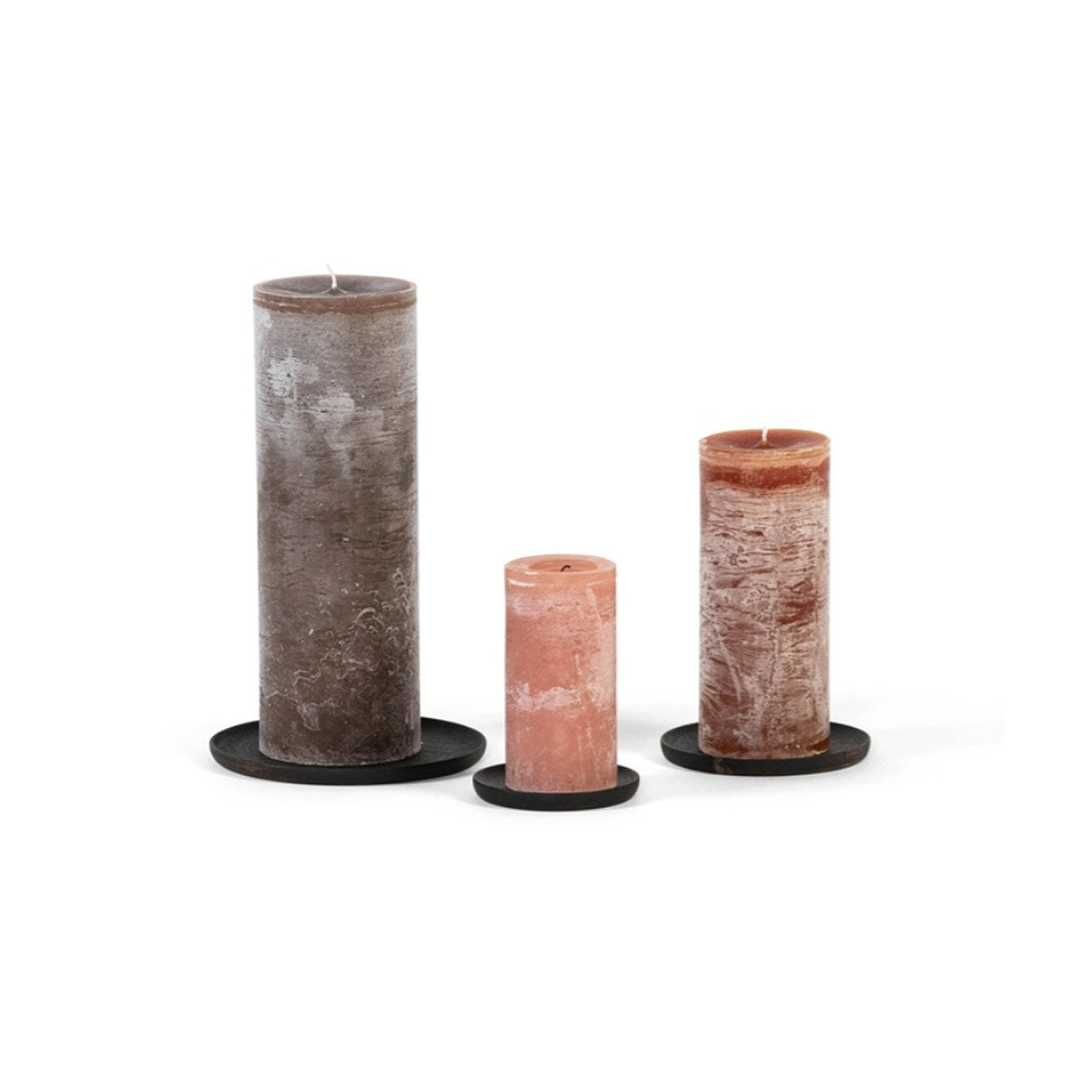 Three round blackened wood candle plates in small, medium, and large sizes displayed with rustic pillar candles