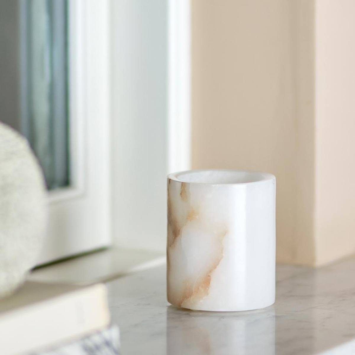 Annabel white alabaster tealight holder with natural veining and polished finish styled on marble top