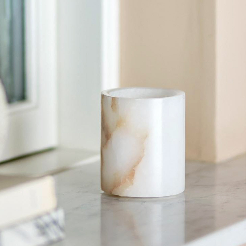 Annabel white alabaster tealight holder with natural veining and polished finish styled on marble top