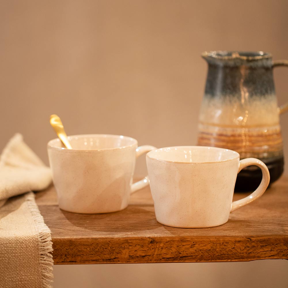 Oatmeal Ceramic Mugs on Wooden Tray with gold spoon, cloth and jug