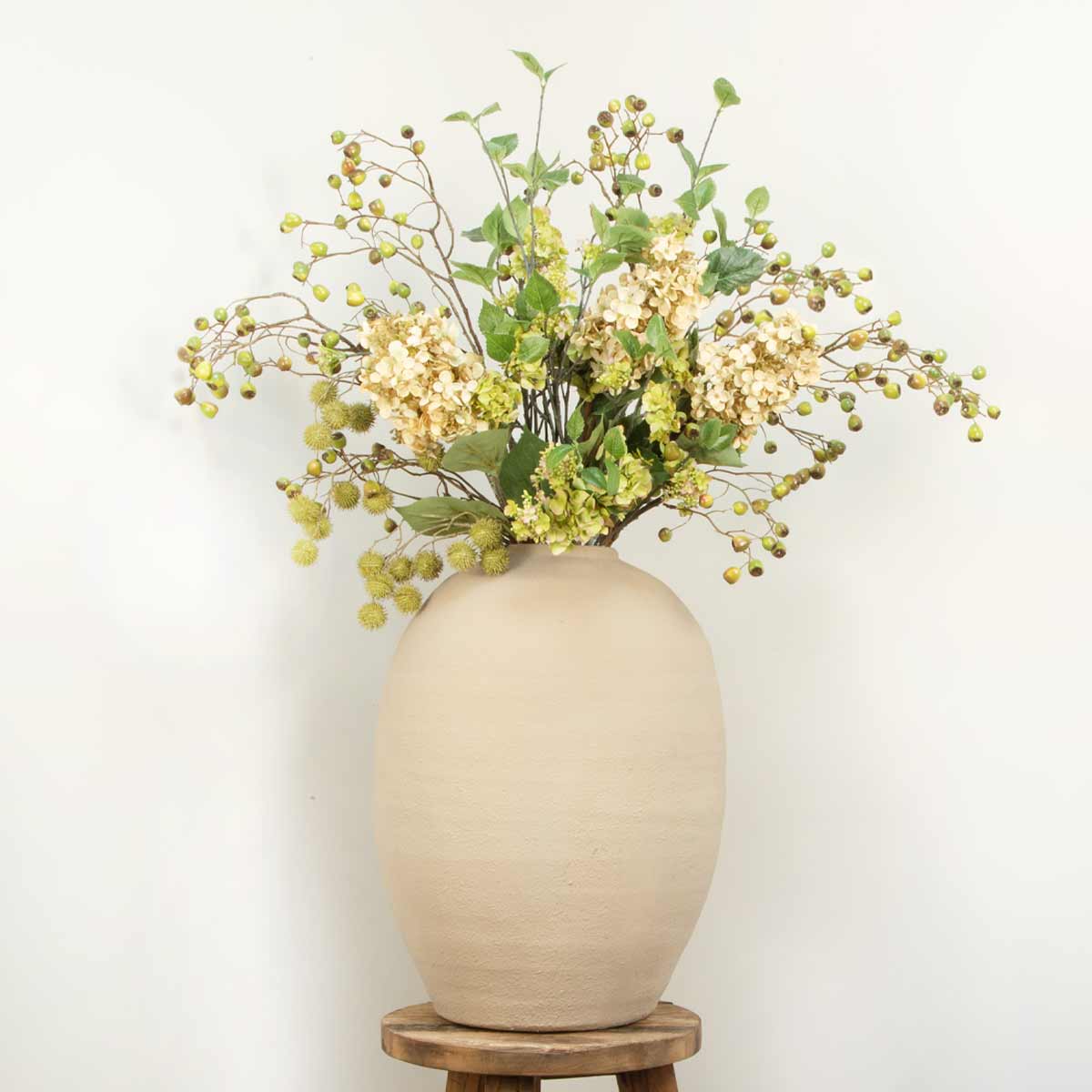 Tall Almond Textured Terracotta Vase – Displayed on rustic wooden stool with faux flower display