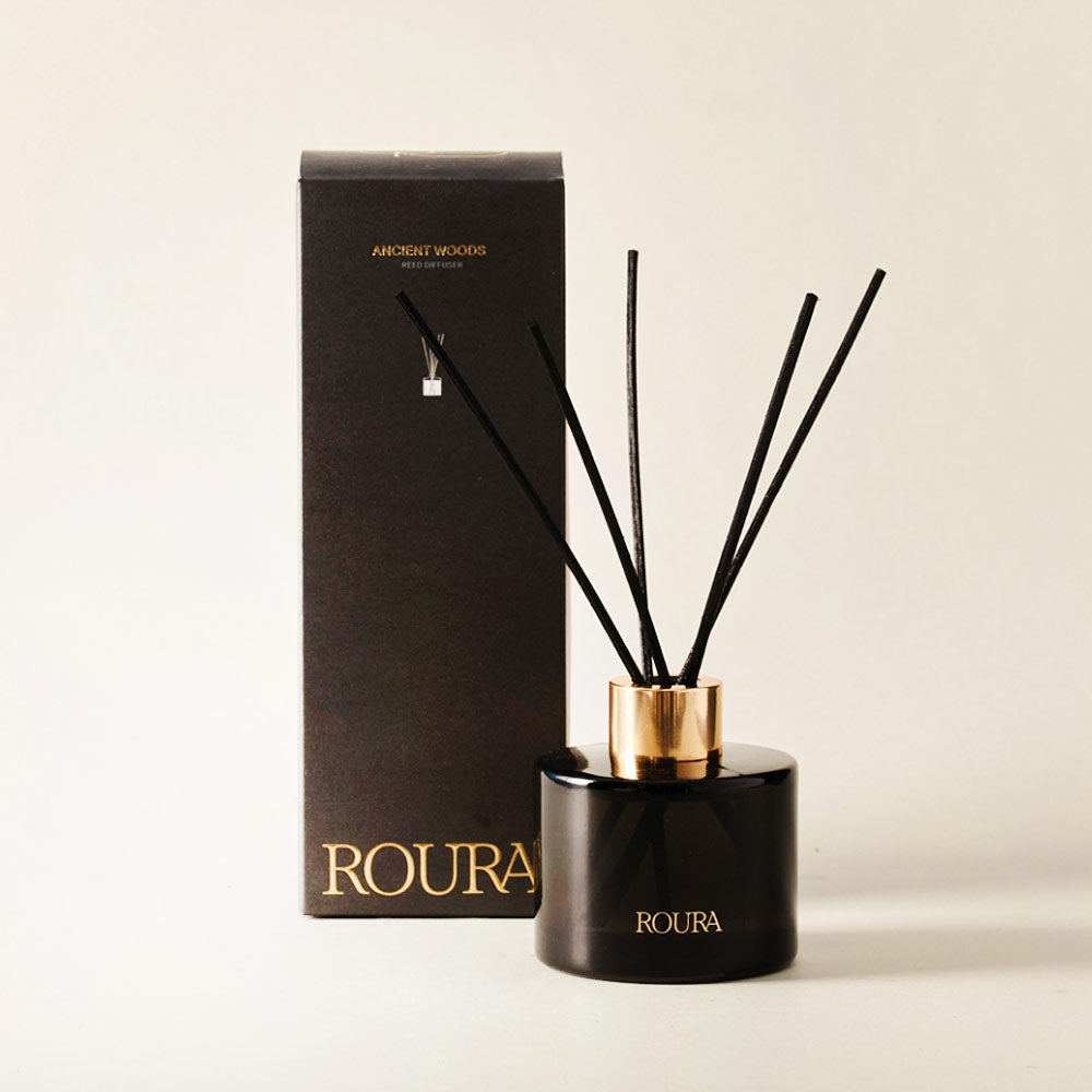 Roura Ancient Woods reed diffuser with 100ml bottle and reed sticks, featuring cedarwood, musk and amber fragrance.