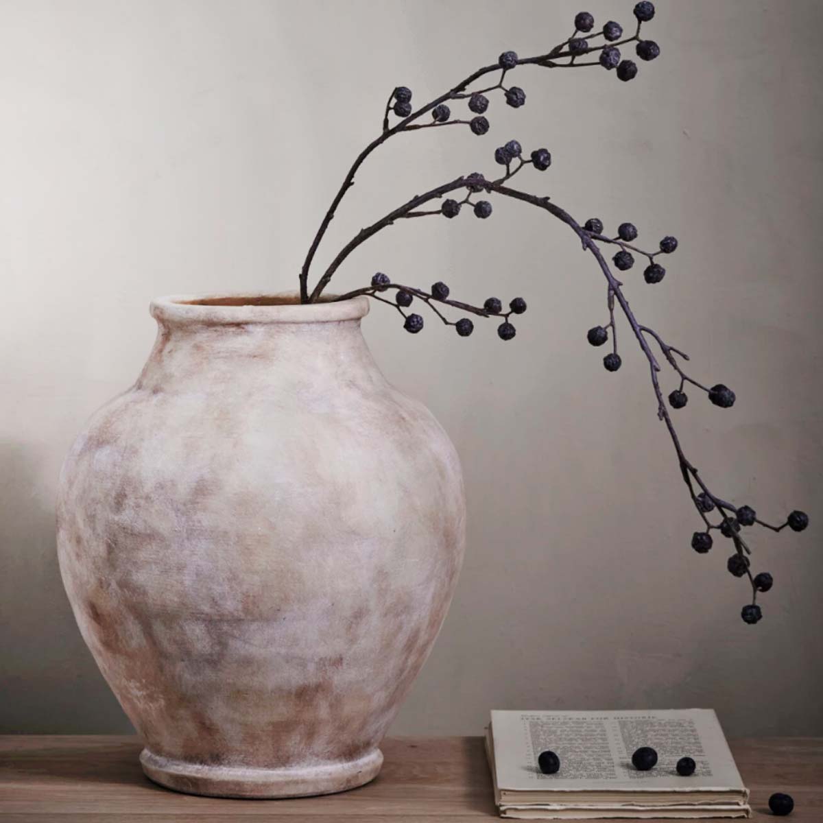 Urn-shaped Anna Clay Vase in antique light brown, handcrafted with a weathered finish, displayed with dried berries on a wooden surface for a rustic, timeless look.