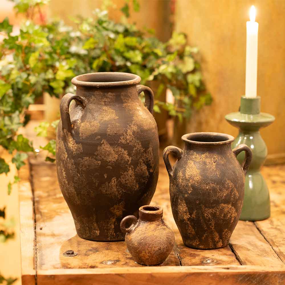 Three rustic clay pots, including two vintage-style Annchi Brown Terracotta Vases in Large and Small on a wooden surface