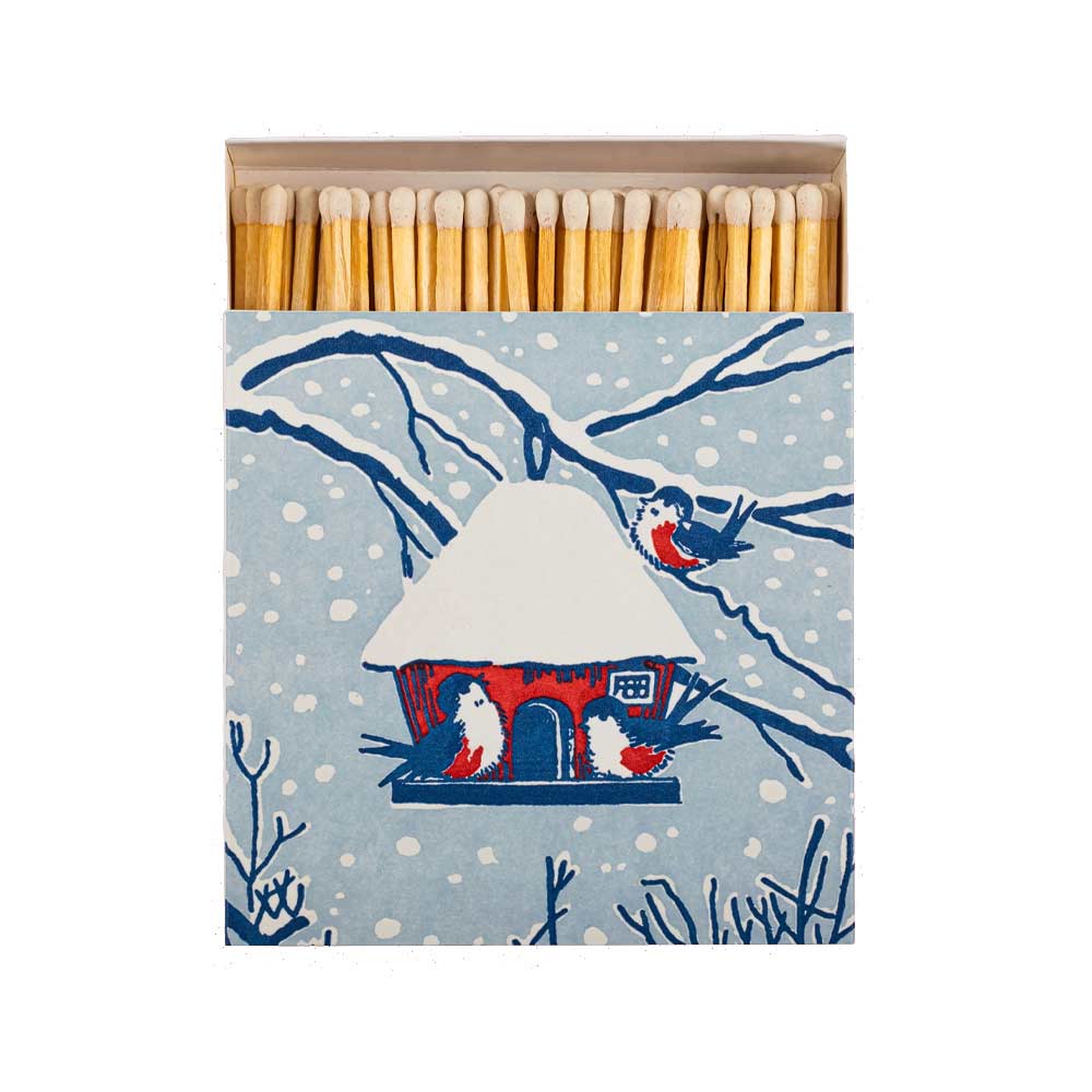Archivist matchbox featuring snowy bird house illustration with three birds - red, blue and white design.