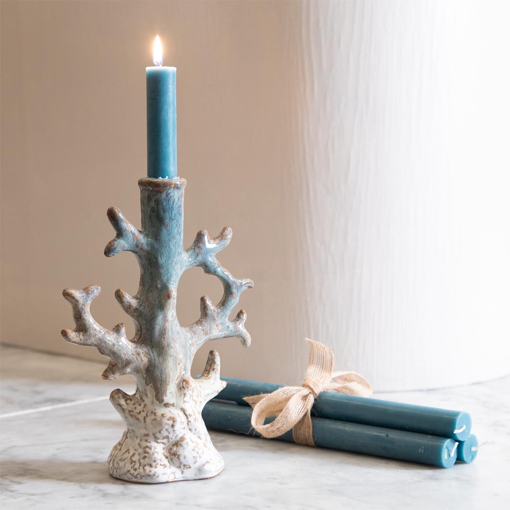 Bridget Stoneware Candle Holder in Blue and Grey is a Decorative coral-style candle holder with a lit blue candle on a neutral background