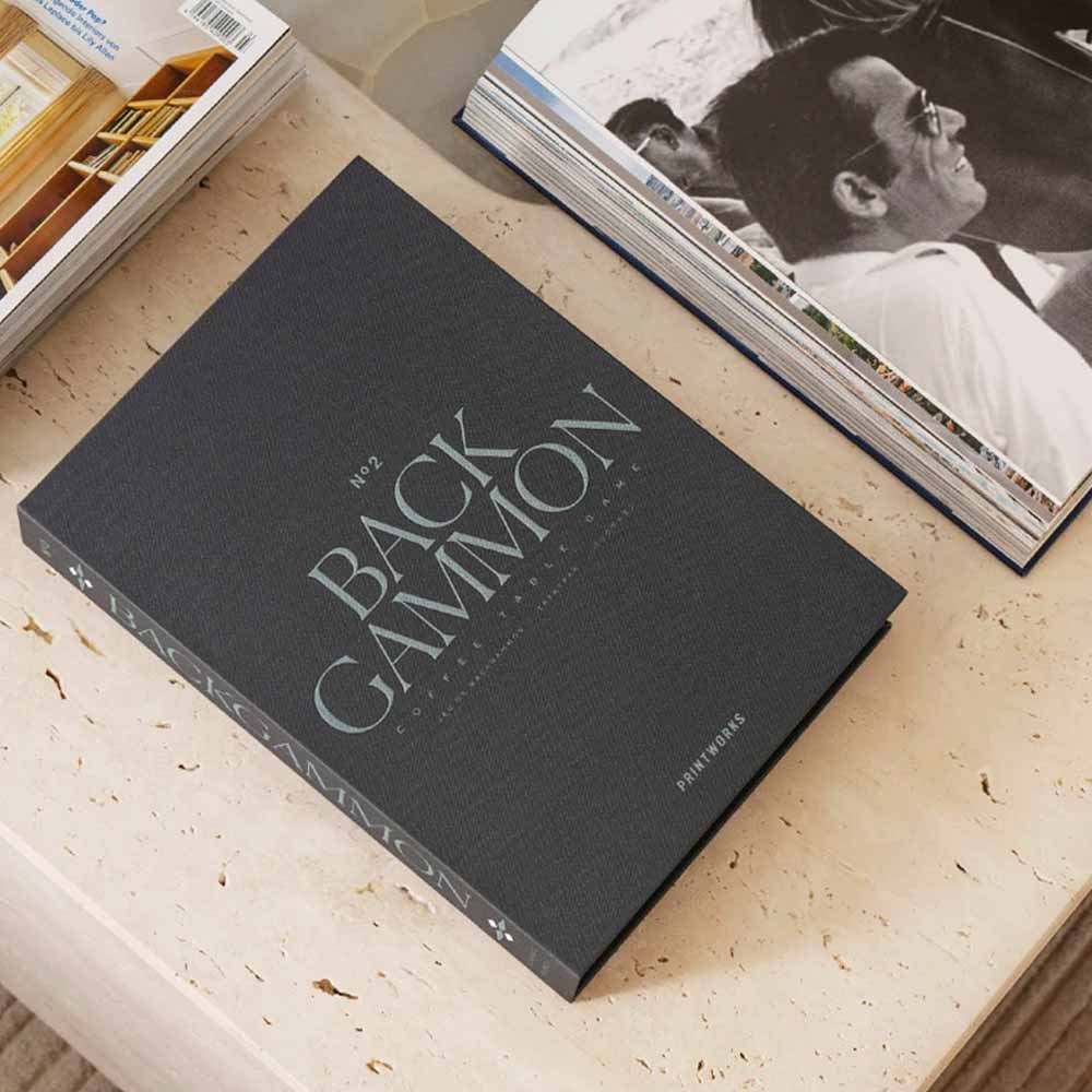 Classic Backgammon Set on a wooden surface with other books in the background.