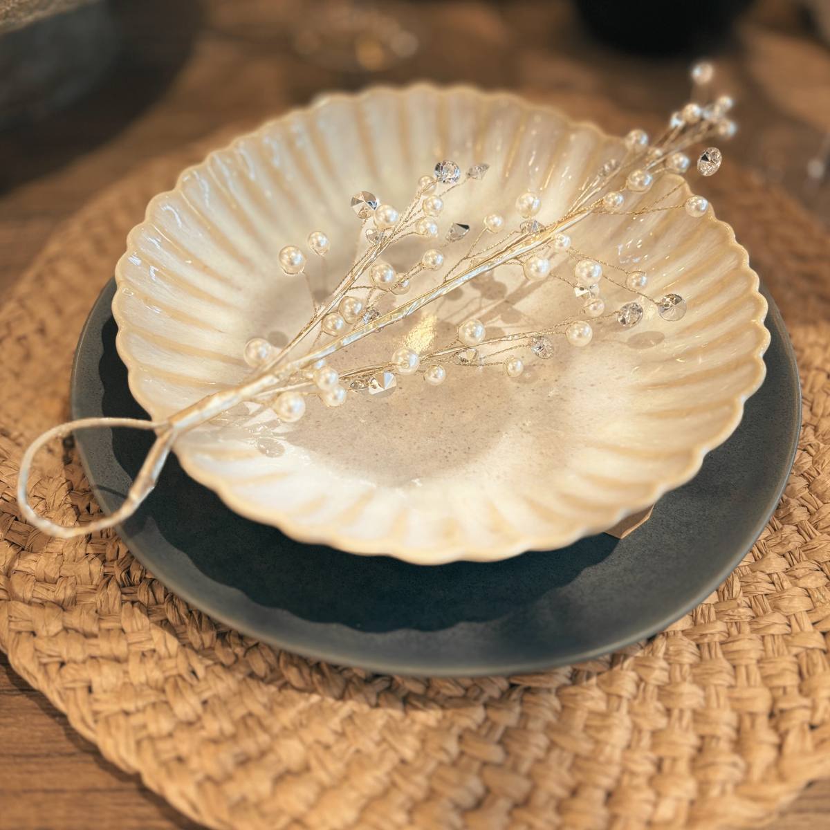Crysilia Light Gold Decorative Mistletoe as part of a table setting on pasta bowl, black dinner plate and woven mat