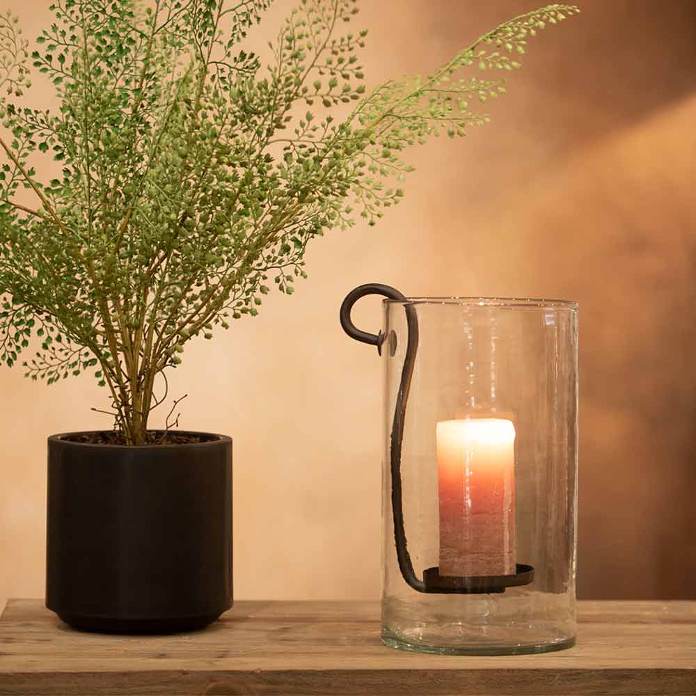 Dolega Glass Hurricane for Pillar Candle on console table with a plant near by