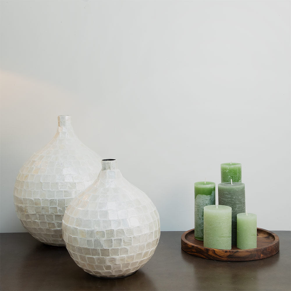 Elorza Bamboo and Shell Decorative Vases in Cream displayed next to a wooden tray of green pillar candles.