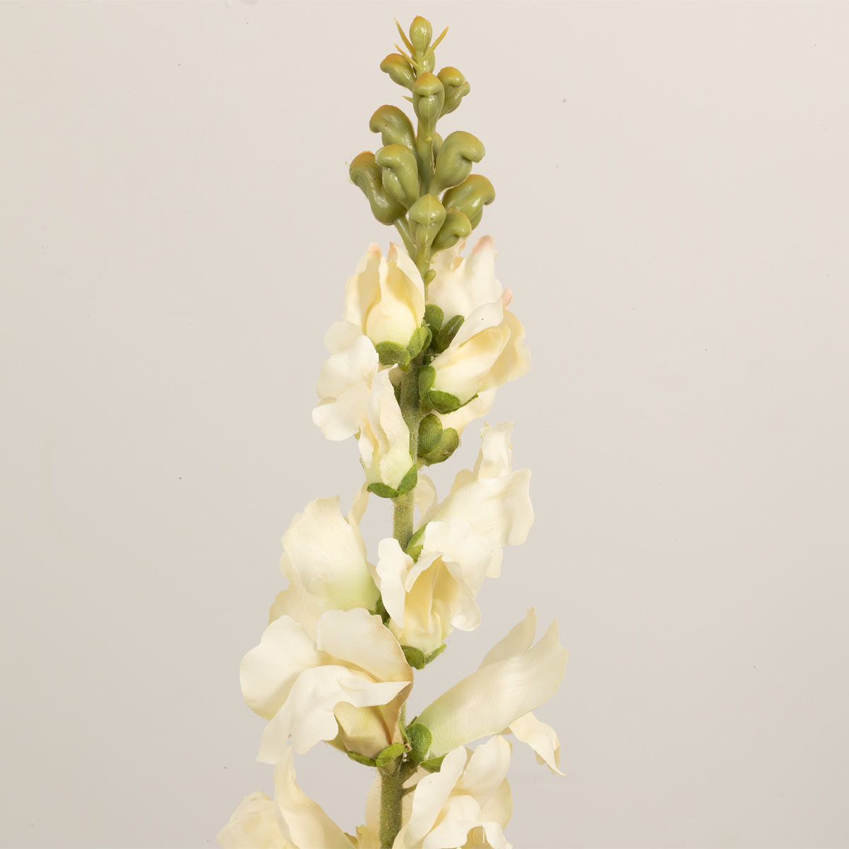 A single stem of cream snapdragon artificial flowers against a neutral background.