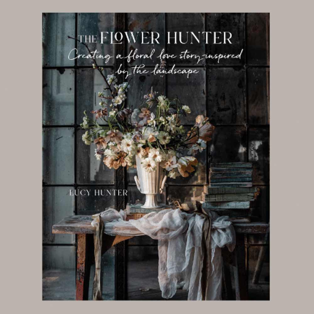 Book cover of 'The Flower Hunter' with a floral arrangement on a wooden table.