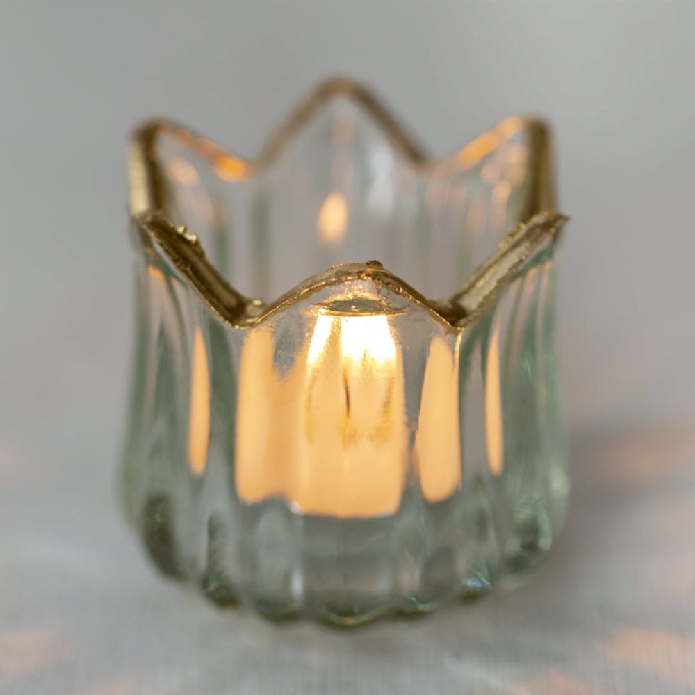 Glass Tulip Tealight Holder with Gold Rim on a soft gray background with lit candle